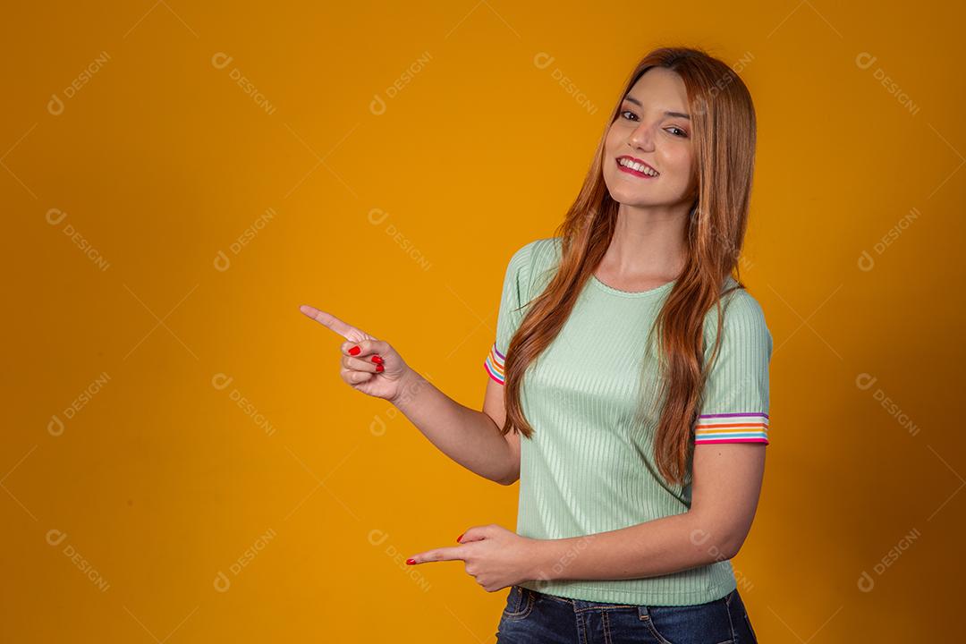 Jovem ruiva apontando no espaço livre