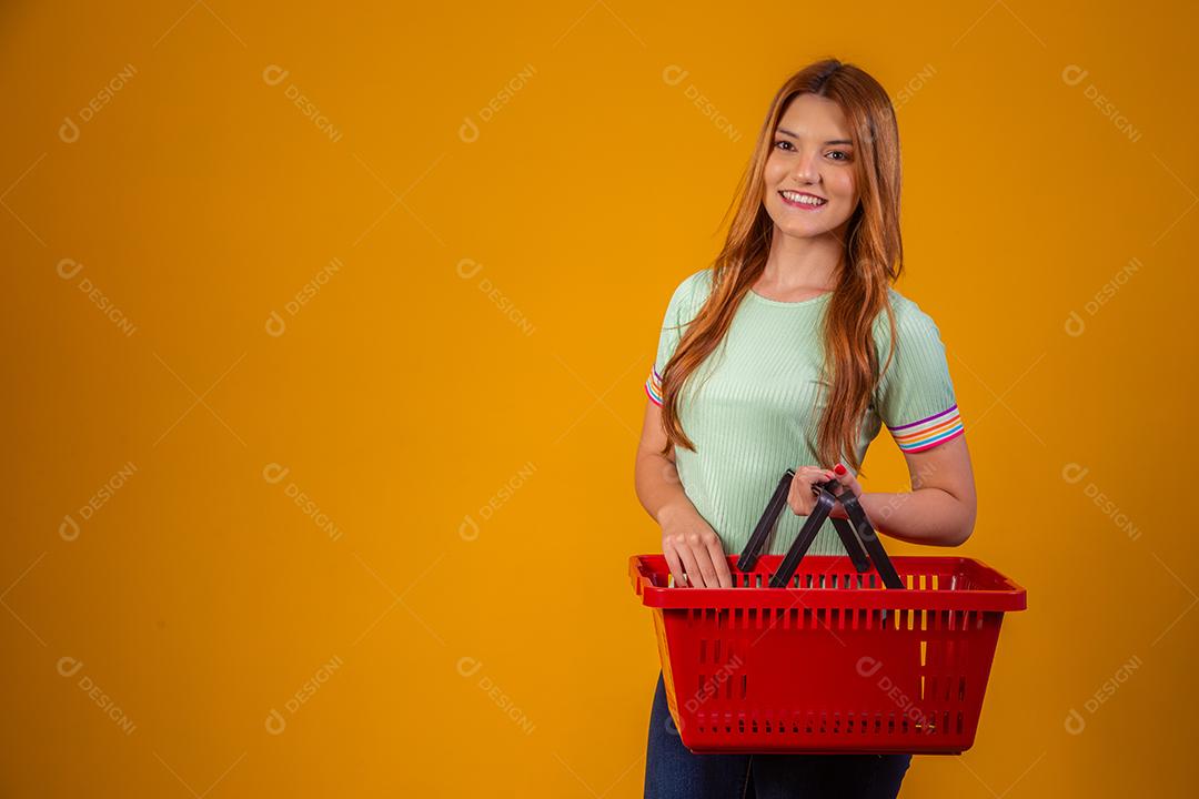 Linda Mulher Ruiva sorridente segurando a cesta de compras vazia