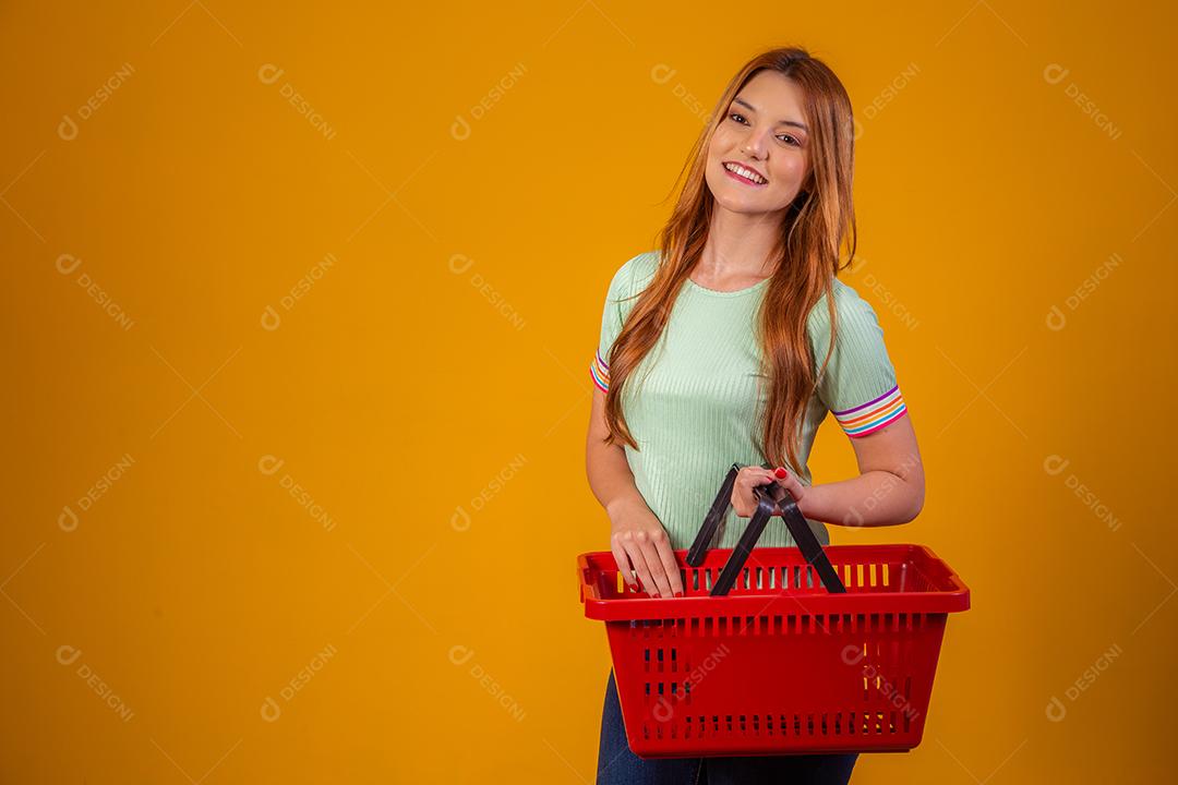 Linda Mulher Ruiva sorridente segurando a cesta de compras vazia