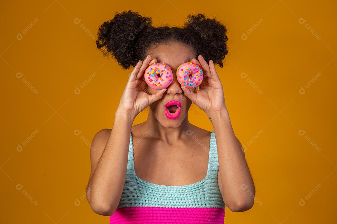 Linda Garota Afro segurando dois Donuts Coloridos