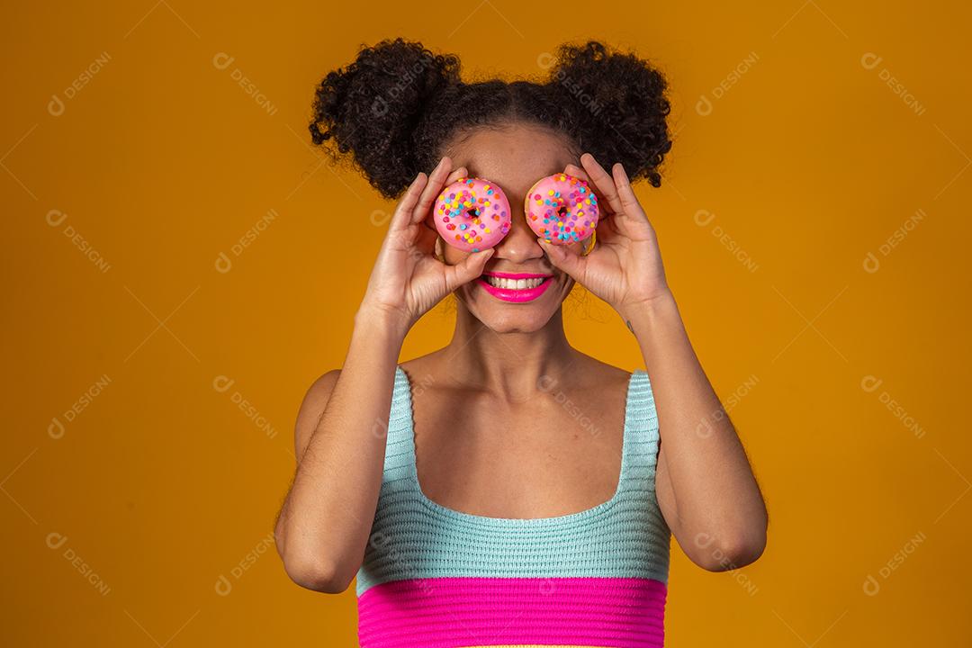 Linda Garota Afro segurando dois Donuts Coloridos