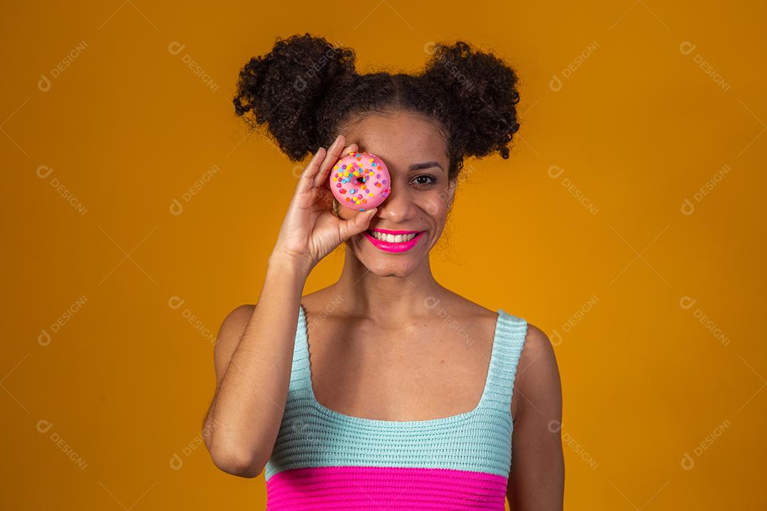 Linda Garota Afro segurando Donuts Coloridos