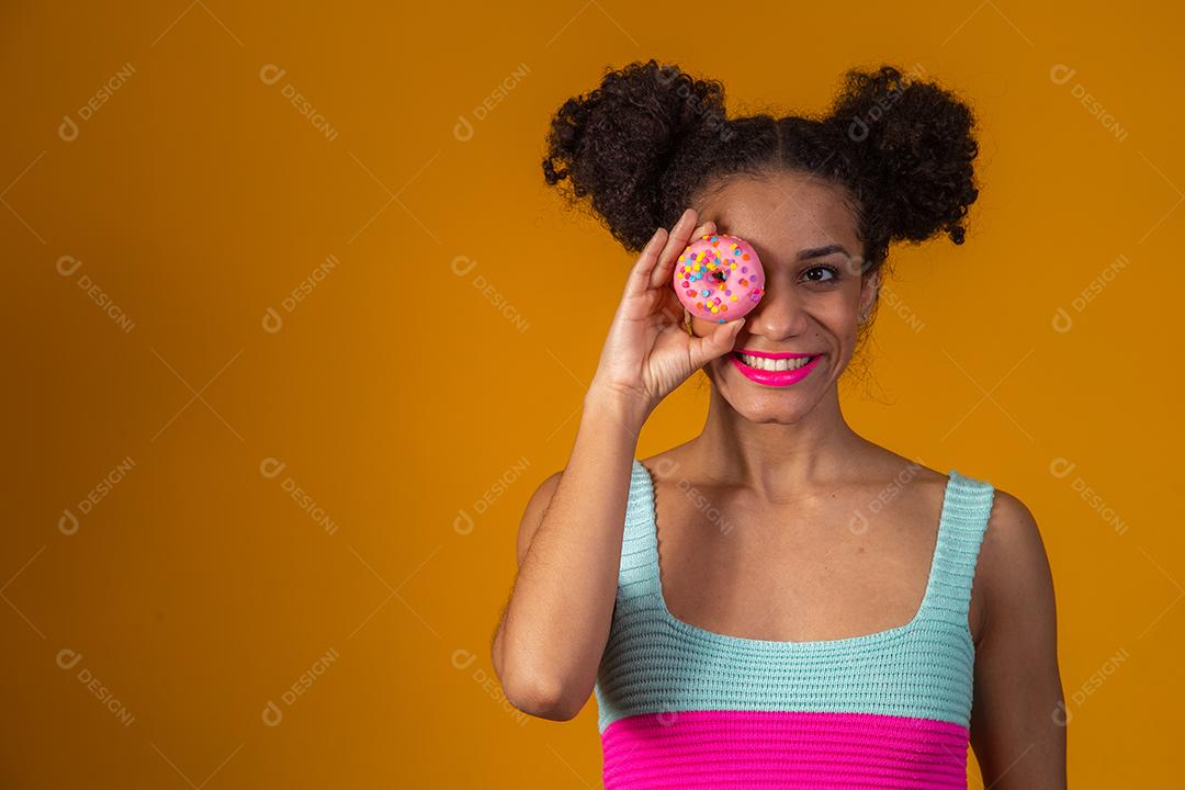 Linda Garota Afro segurando Donuts Coloridos