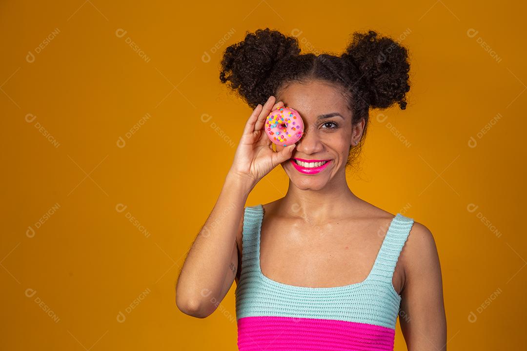 Linda Garota Afro segurando Donuts Coloridos