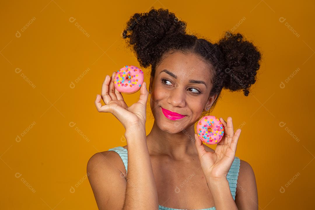 Linda Garota Afro segurando Donuts Coloridos