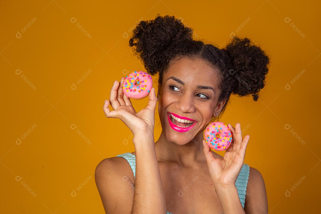 Linda Garota Afro segurando Donuts Coloridos
