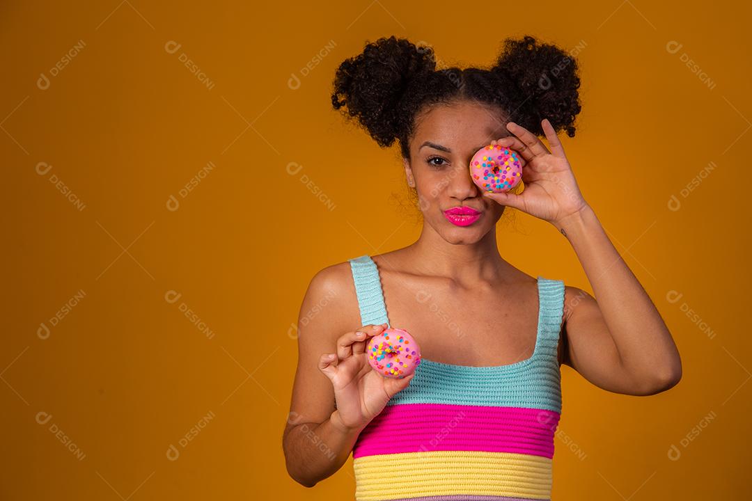 Linda Garota Afro segurando Donuts Coloridos