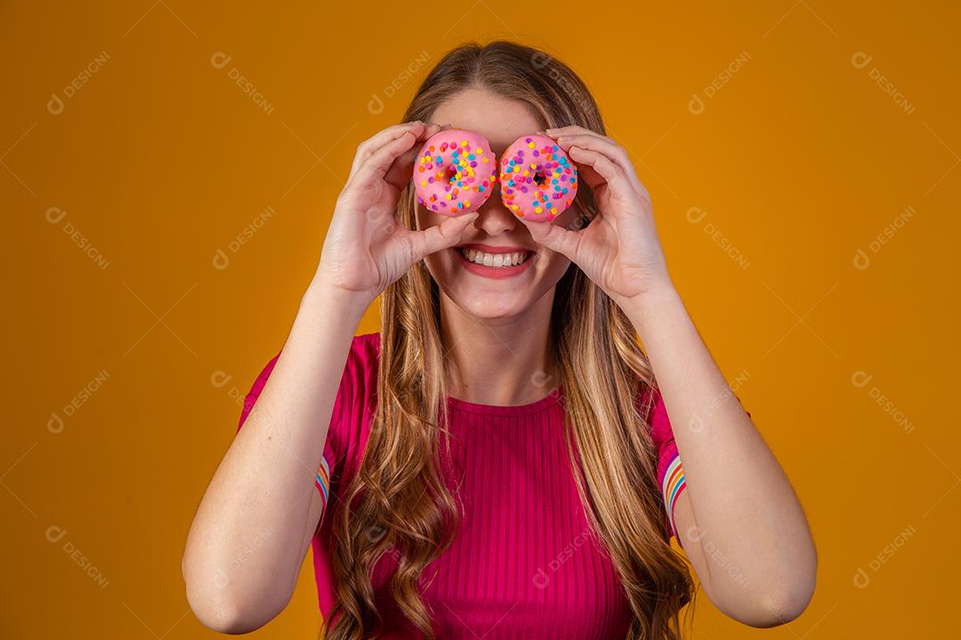 Linda Garota Loira segurando Donuts Coloridos