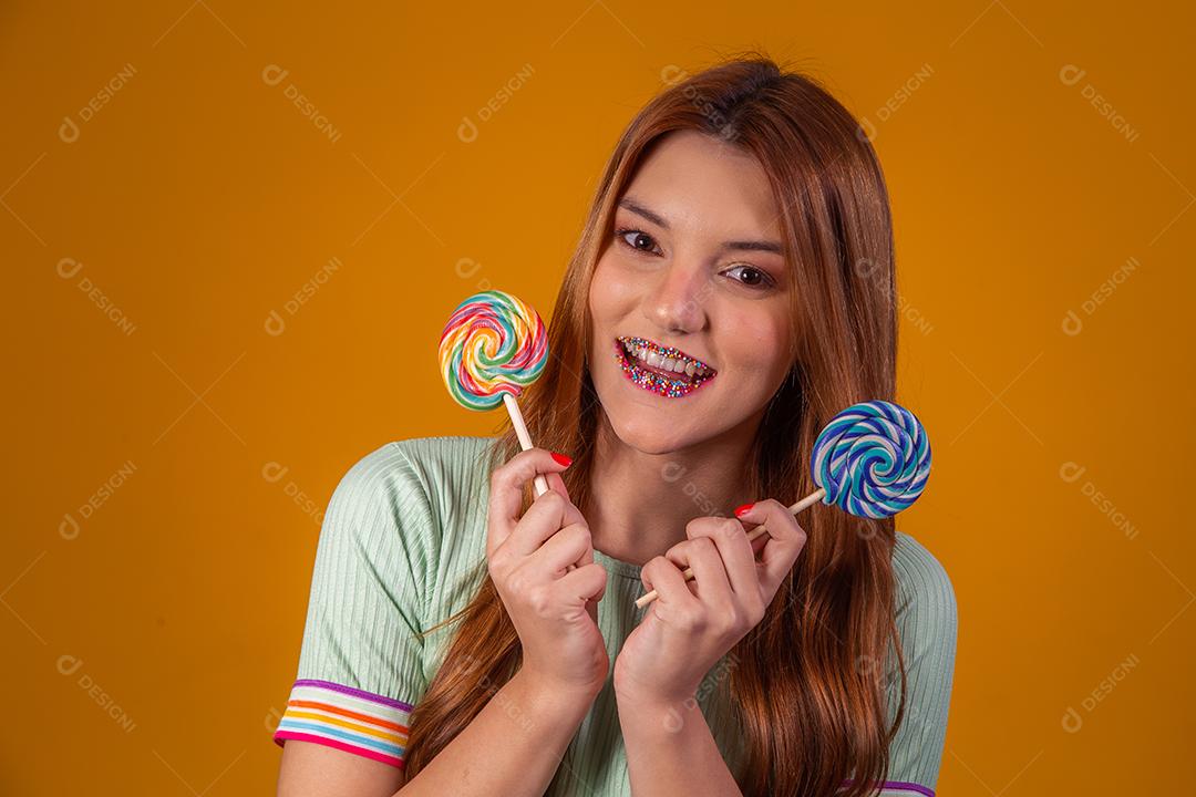 Linda Jovem Ruiva com pirulitos coloridos