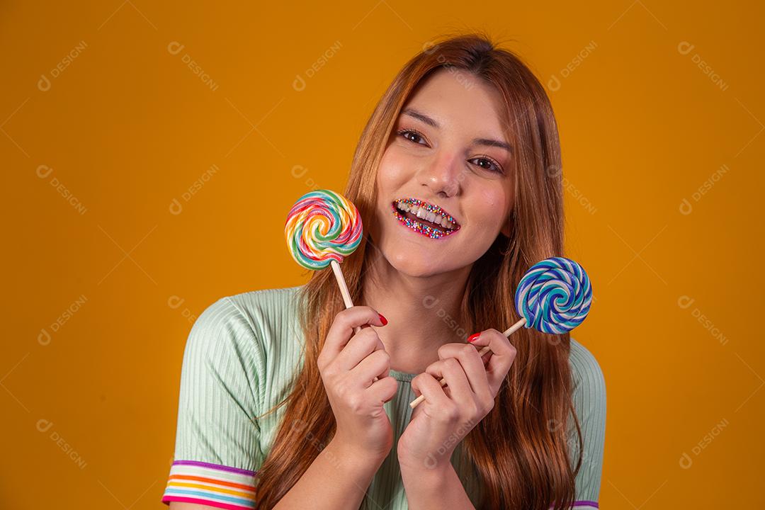 Linda Jovem Ruiva com pirulitos coloridos