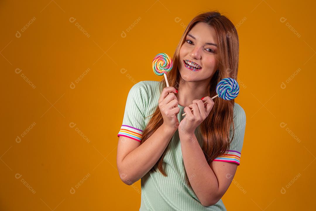 Linda Jovem Ruiva com pirulitos coloridos