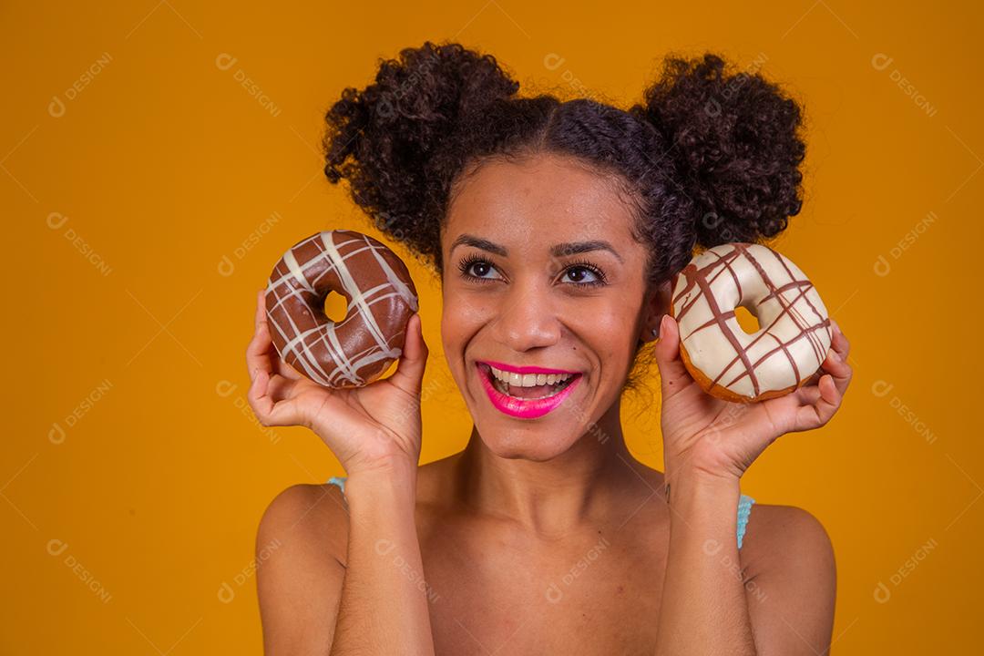 Linda Garota Afro segurando duas Rosquinha