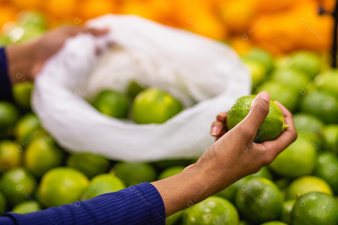 jovem no supermercado comprando laranja