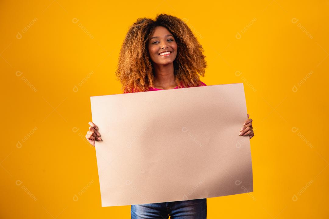 Mulher afro segurando cartolina marrom em fundo amarelo