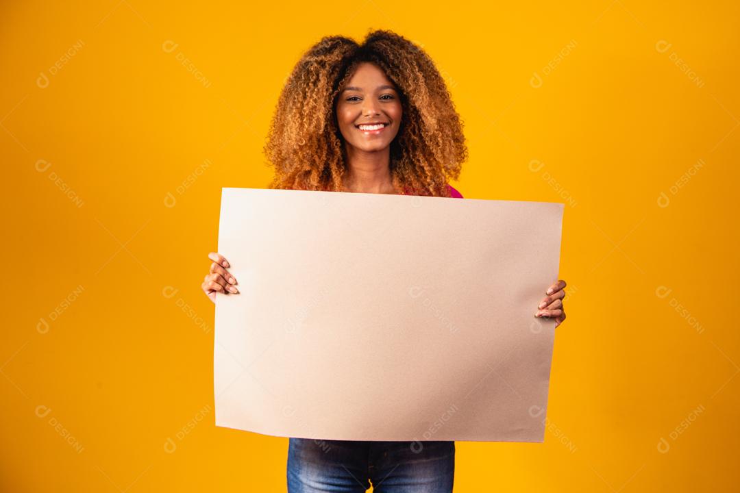 Mulher afro segurando cartolina marrom em fundo amarelo