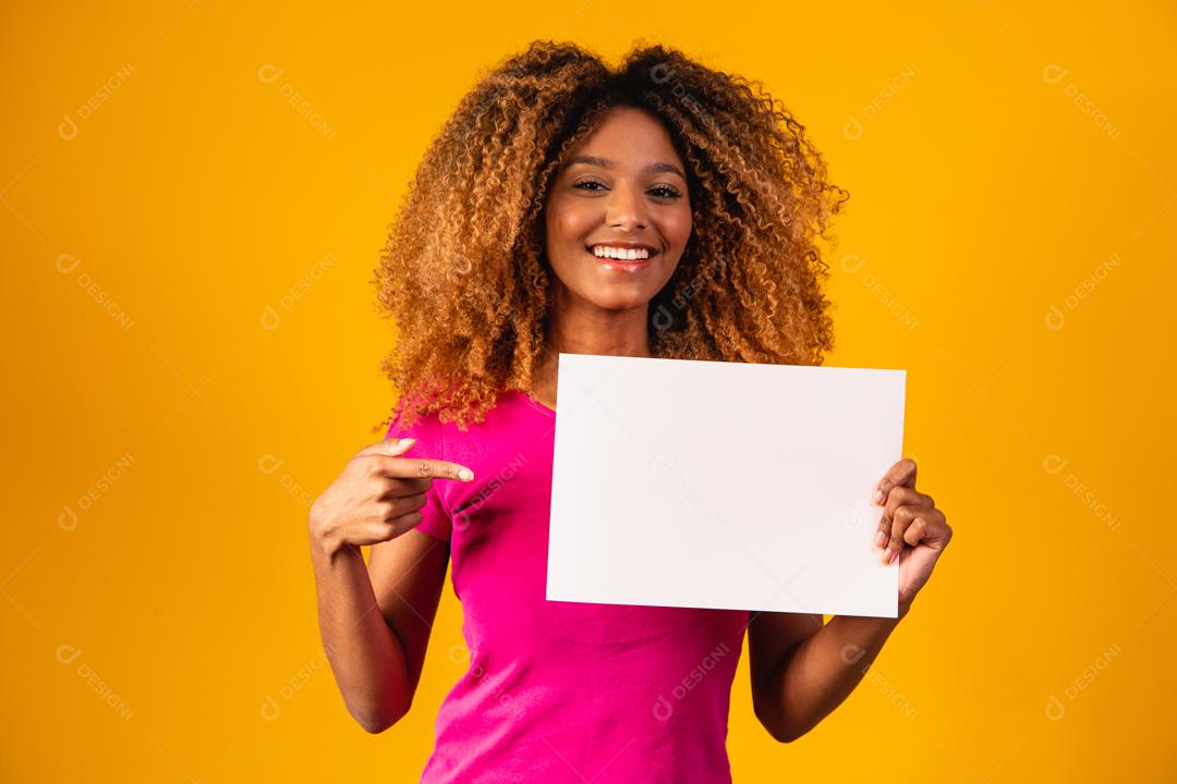 Mulher afro segurando cartolina marrom em fundo amarelo