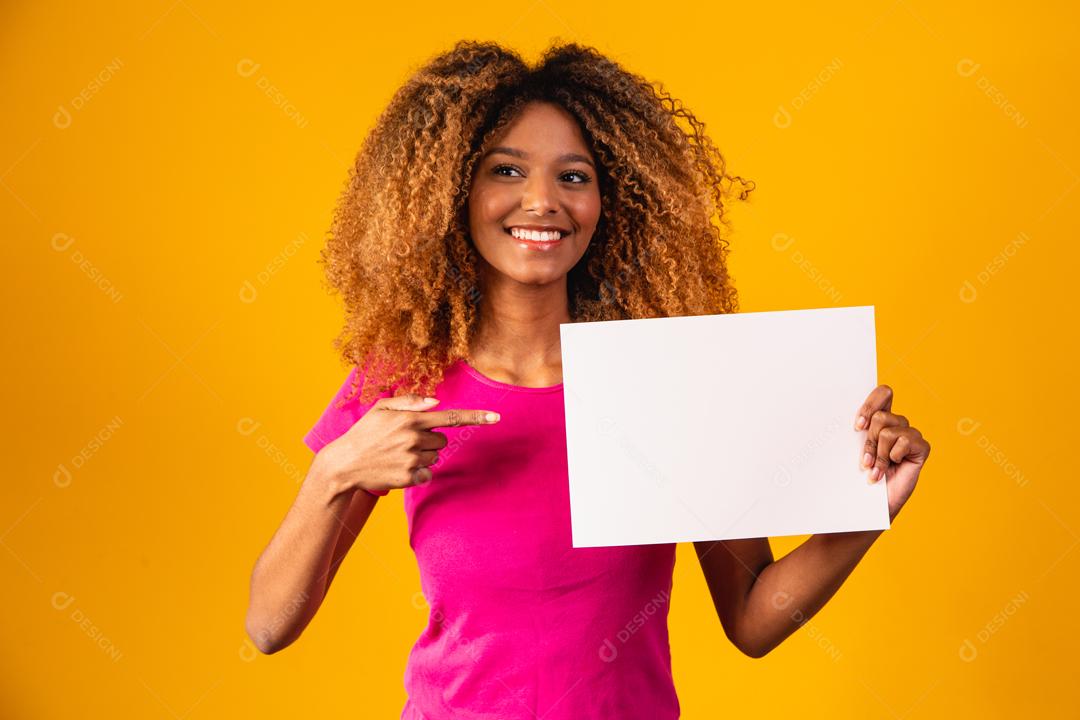 Mulher afro segurando Papel Branco em fundo amarelo