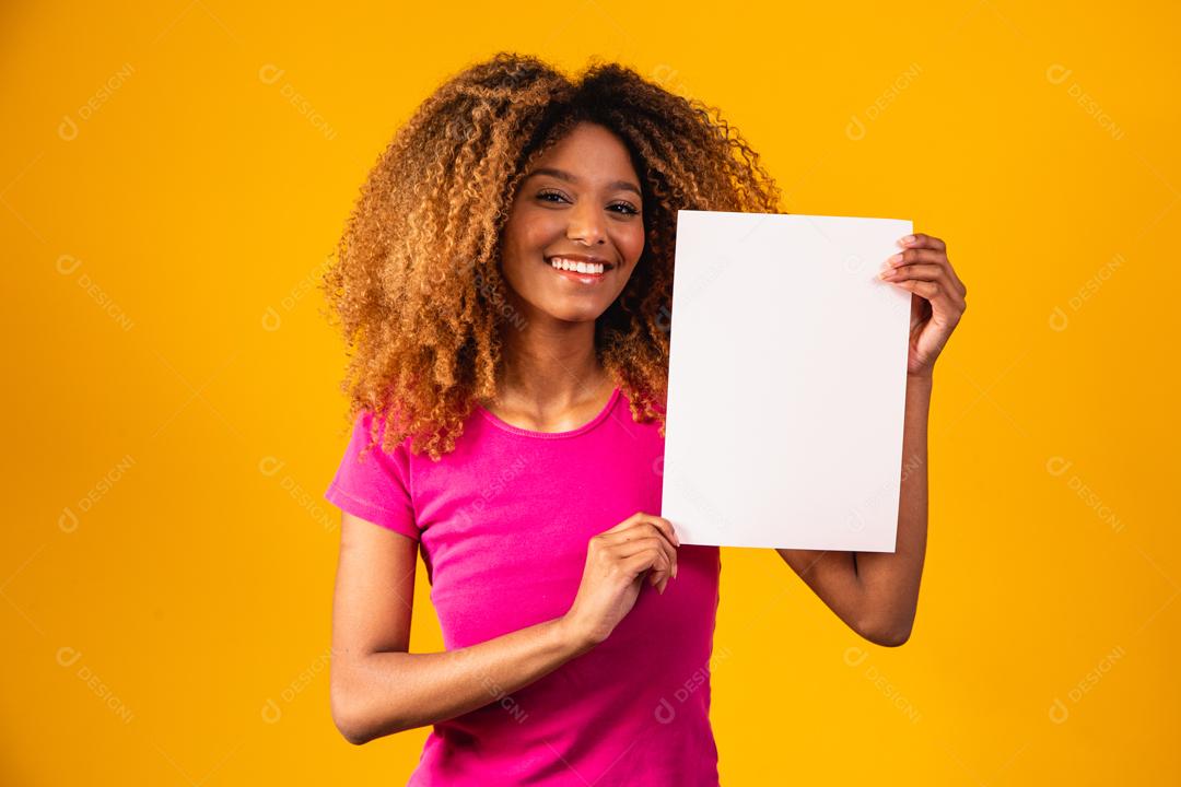 Mulher afro segurando Papel Branco em fundo amarelo