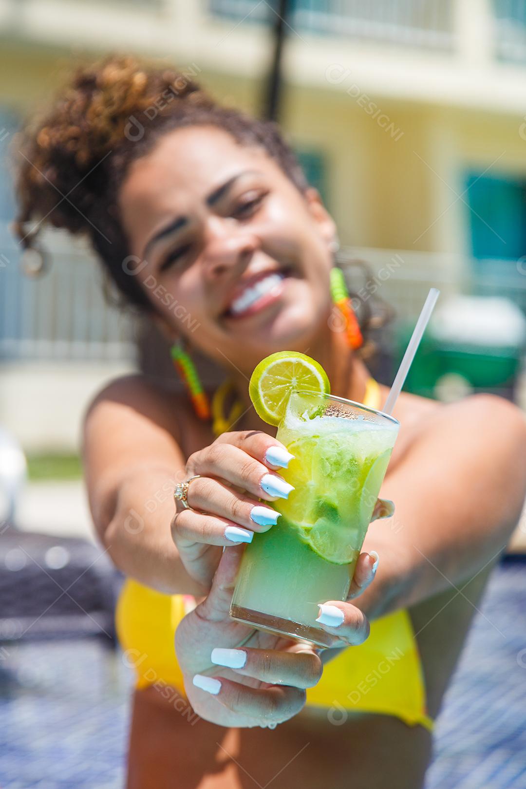 Mulher de biquini sentada em beira de piscina em hotel