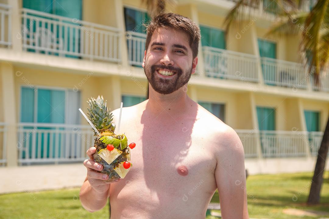 homem de férias em risort bebendo doce de abacaxi.