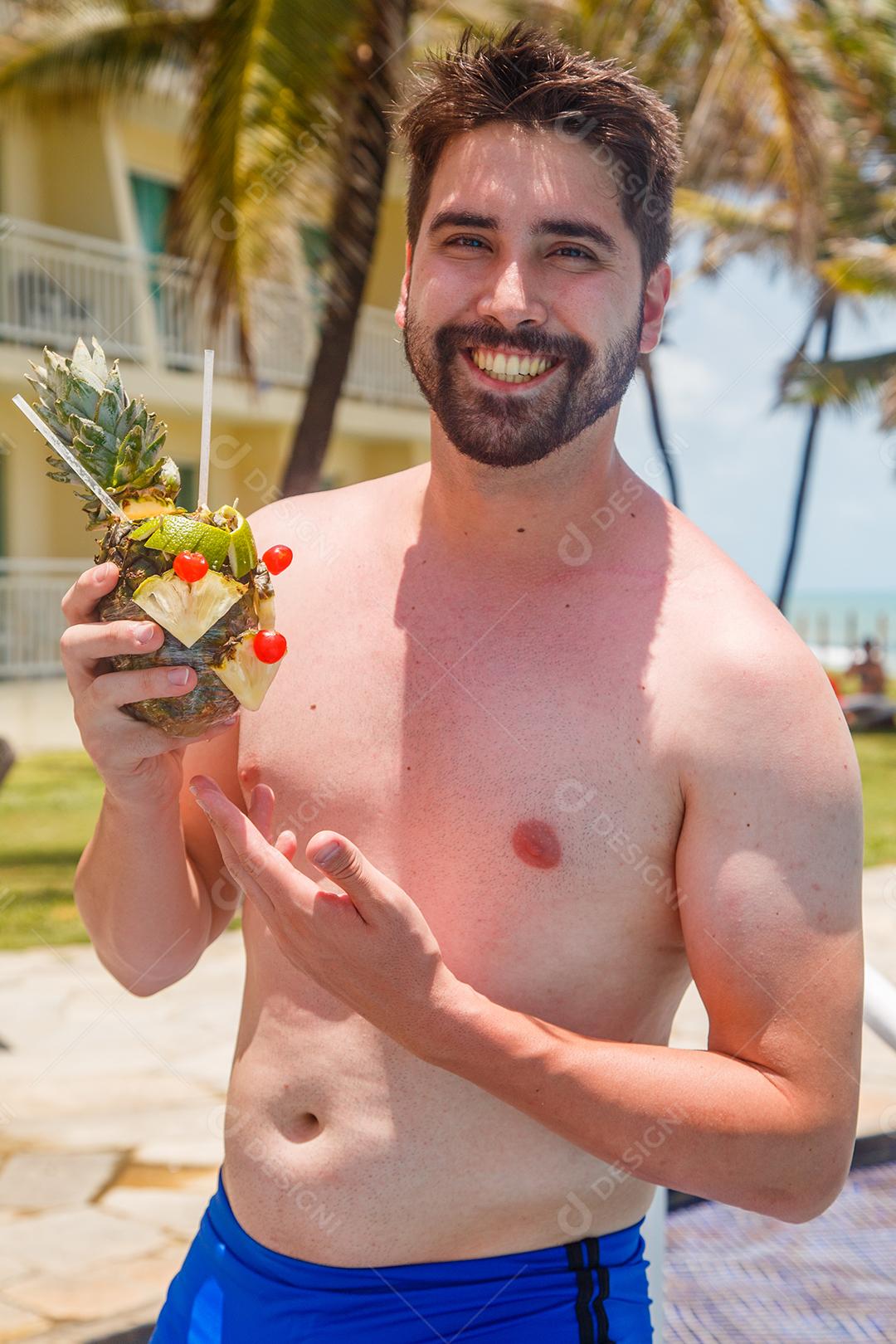 homem de férias em risort bebendo doce de abacaxi.