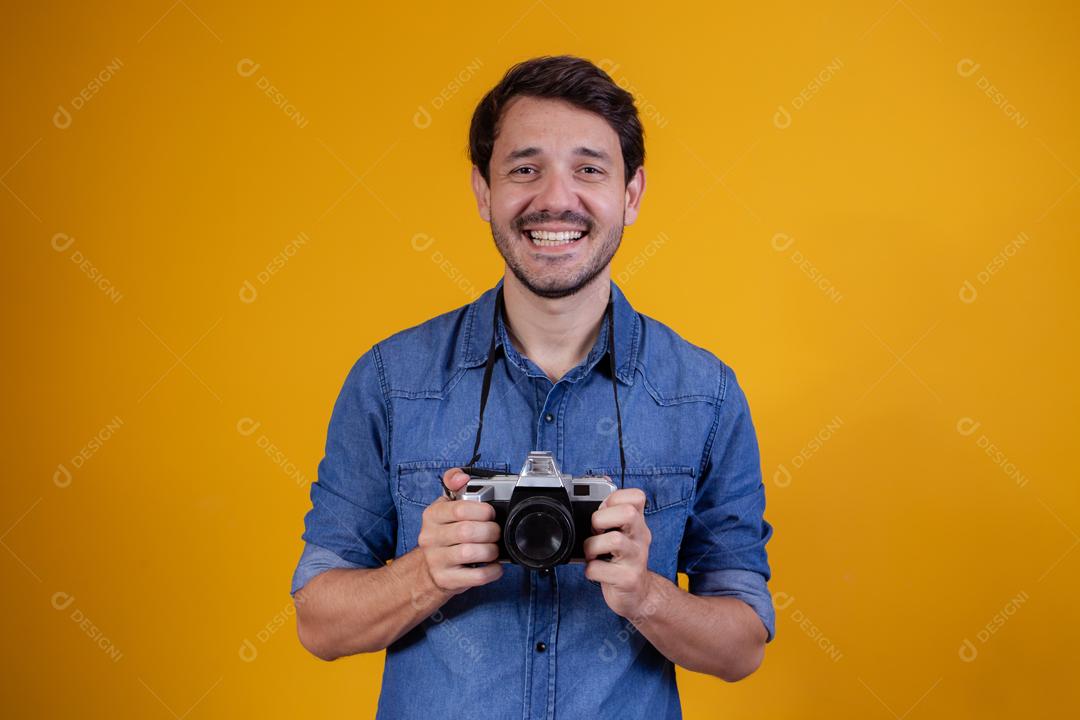 Fotógrafo em fundo amarelo homem com uma câmera fotográfica