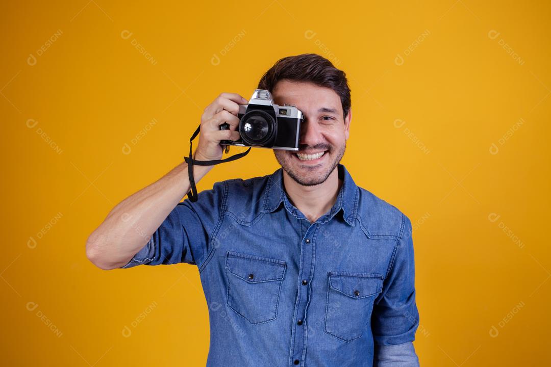 Fotógrafo em fundo amarelo homem com uma câmera fotográfica