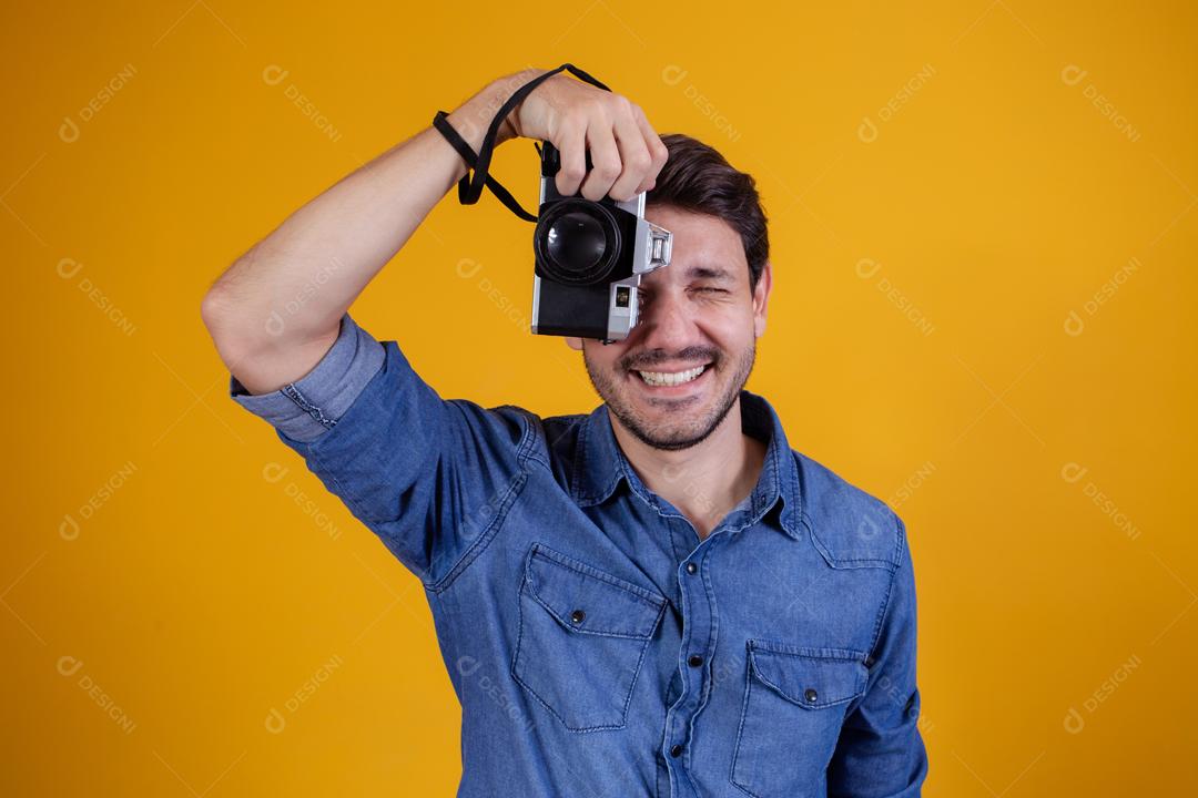 Fotógrafo em fundo amarelo homem com uma câmera fotográfica