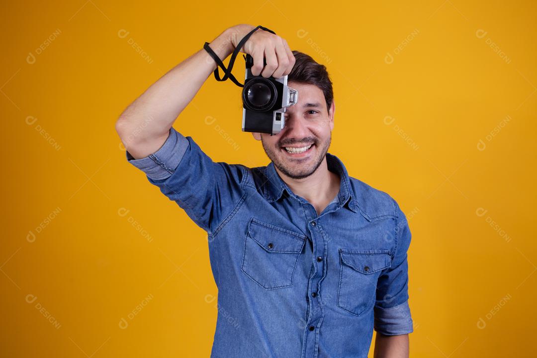 Fotógrafo em fundo amarelo homem com uma câmera fotográfica