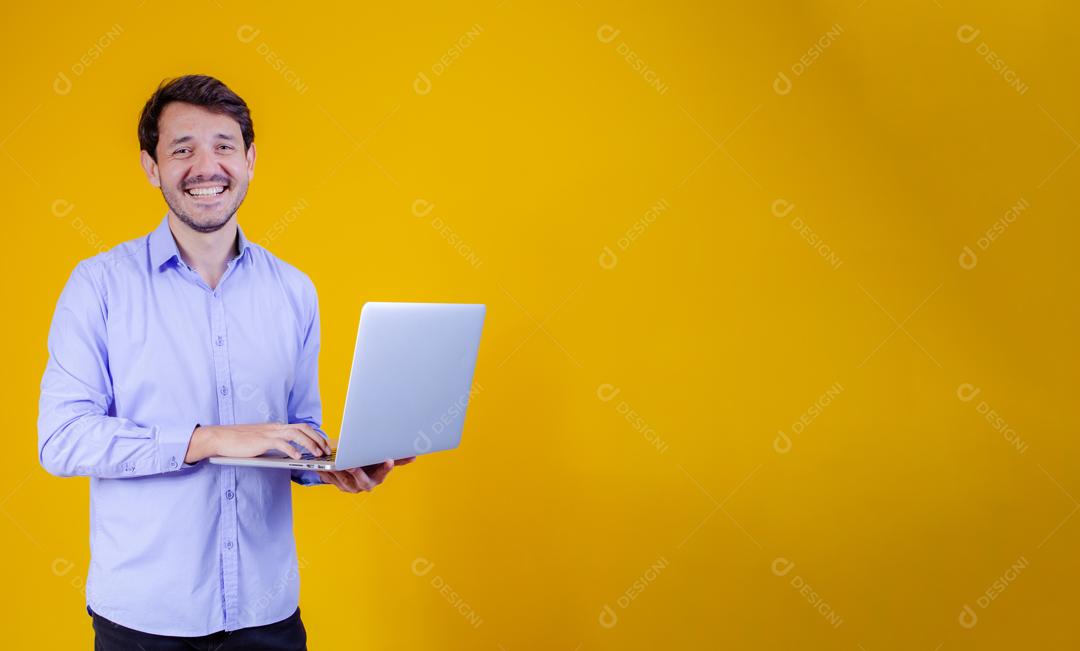 Homem com camisa social manga longa em fundo amarelo Segurando Notebook Computador