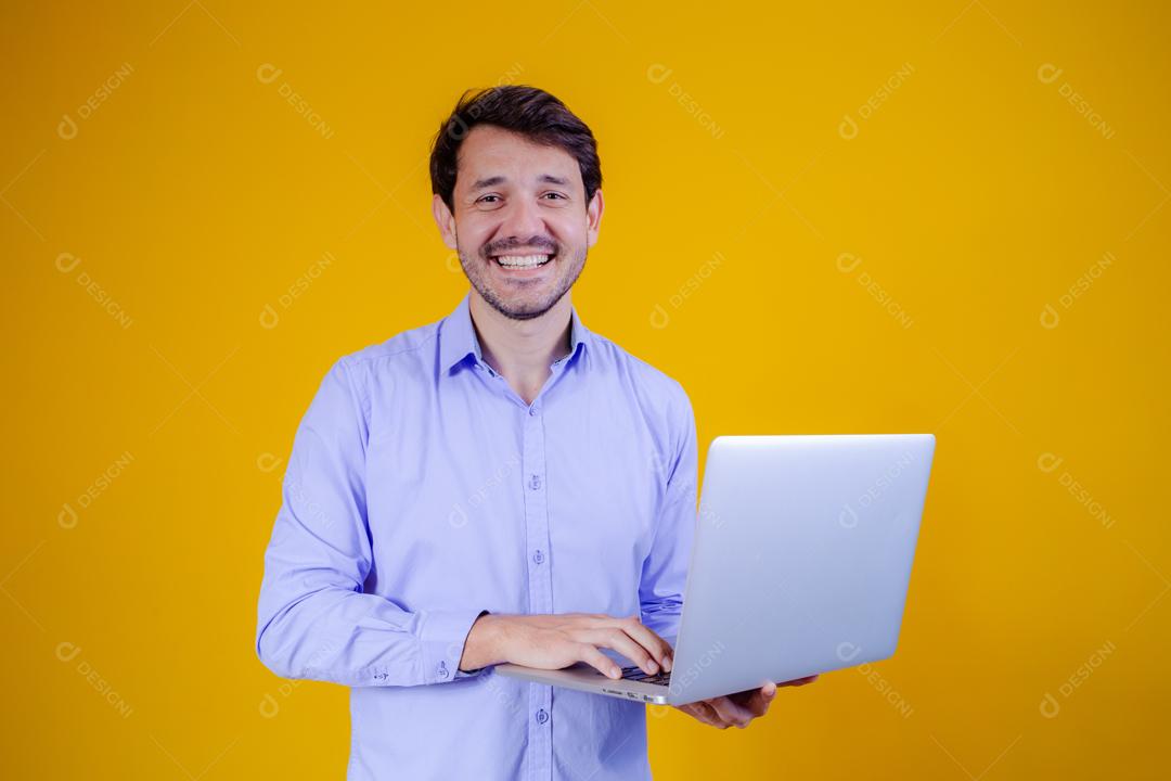 Homem com camisa social manga longa em fundo amarelo Segurando Notebook Computador