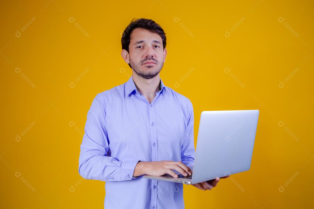 Homem com camisa social manga longa em fundo amarelo Segurando Notebook Computador