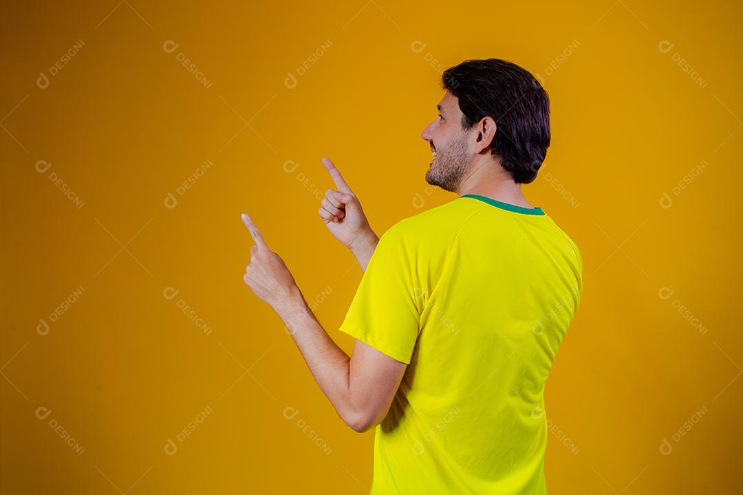 homem brasileiro na blusa brasileira com retrovisor apontando para o lado