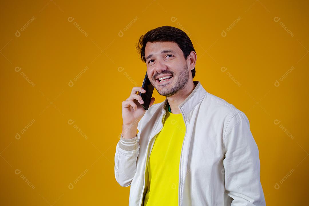 homem falando no telefone com espaço para texto em fundo amarelo. homem ligando pelo celular
