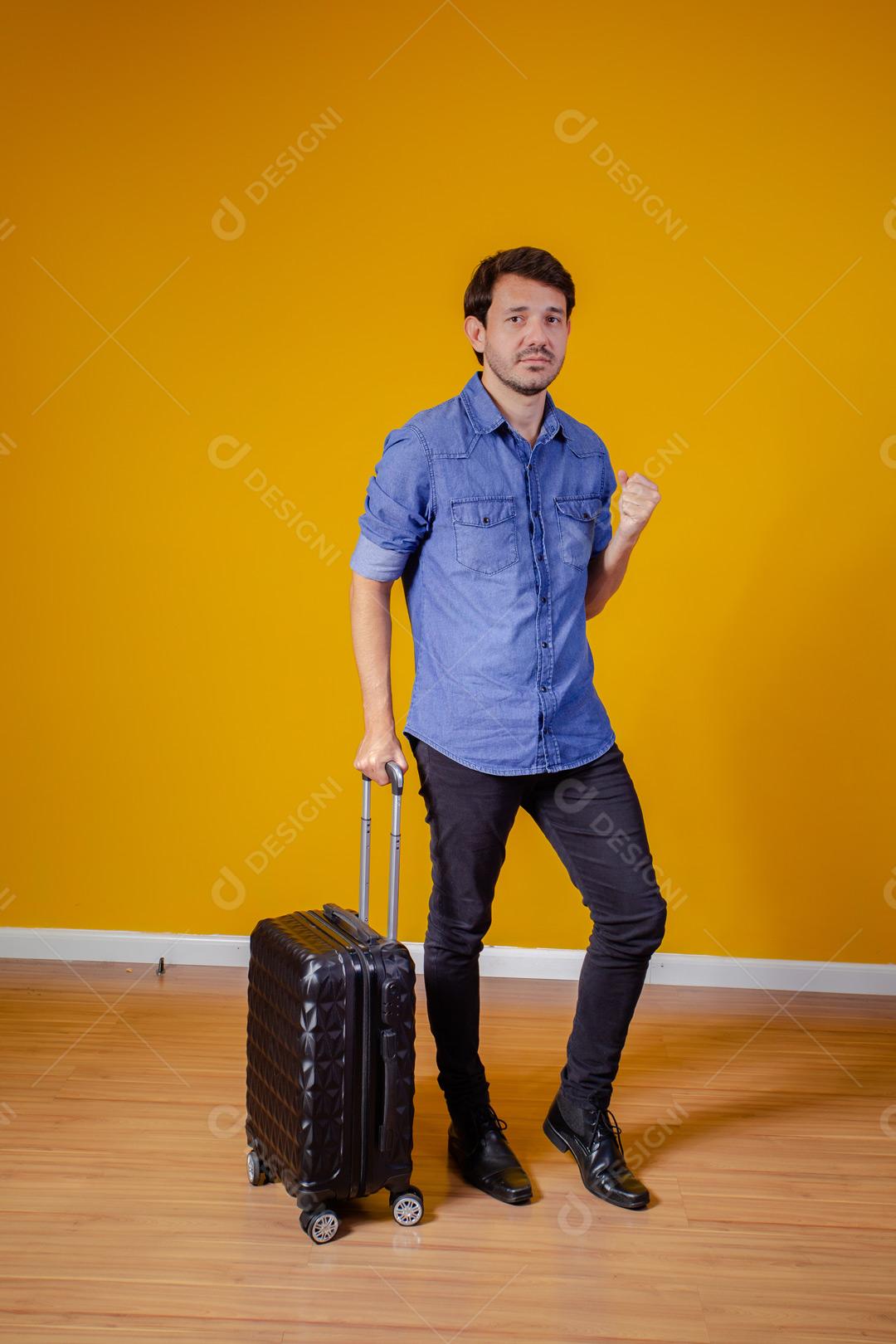 Homem com roupa social segurando mala preta com expressão de feliz