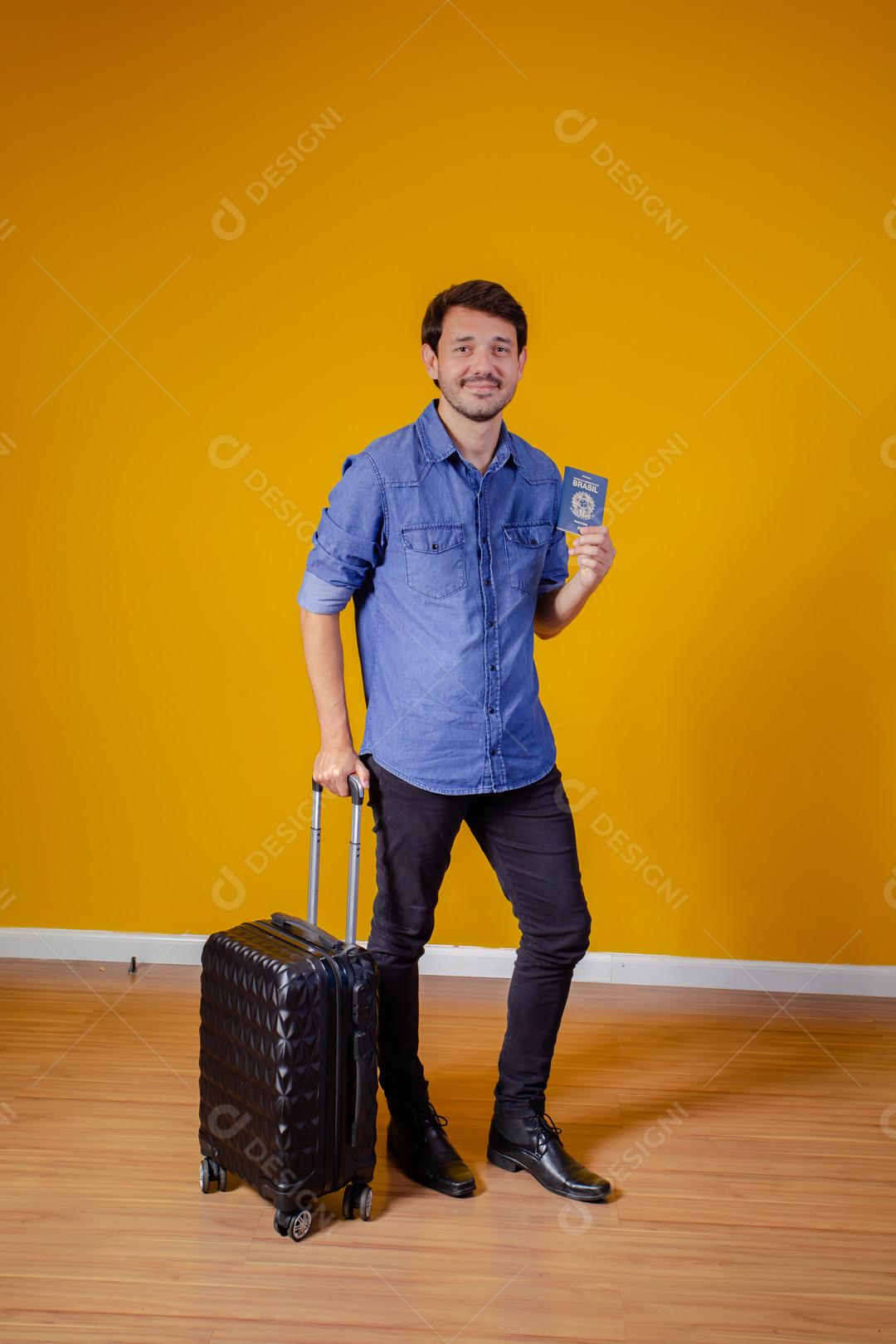 Homem com roupa social segurando mala preta e passaporte