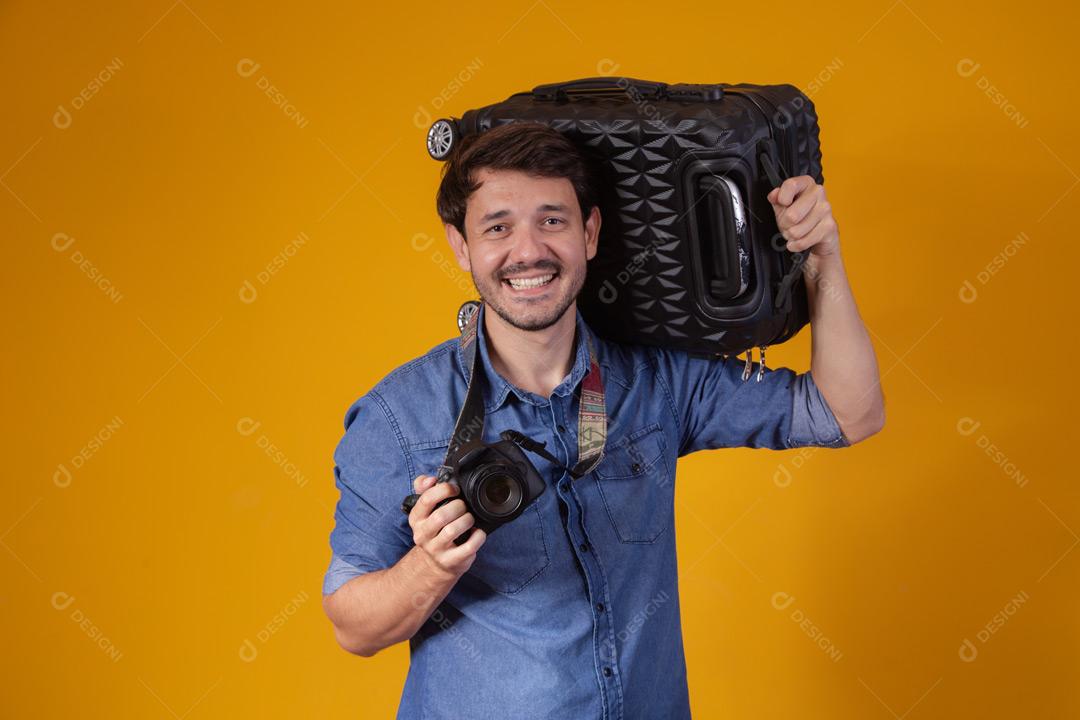 Homem com roupa social segurando mala preta e passaporte