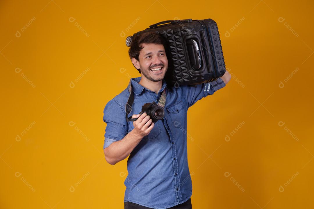 Homem com roupa social segurando mala preta e passaporte