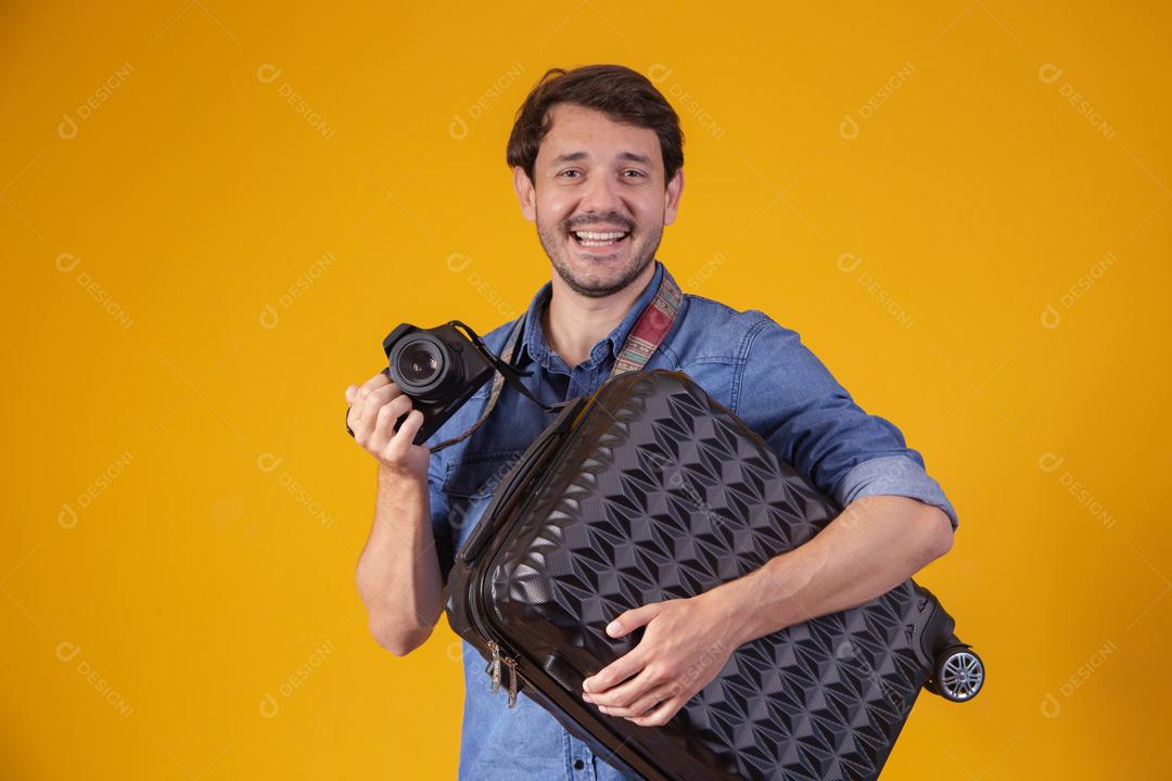 Homem com roupa social segurando mala preta e câmera