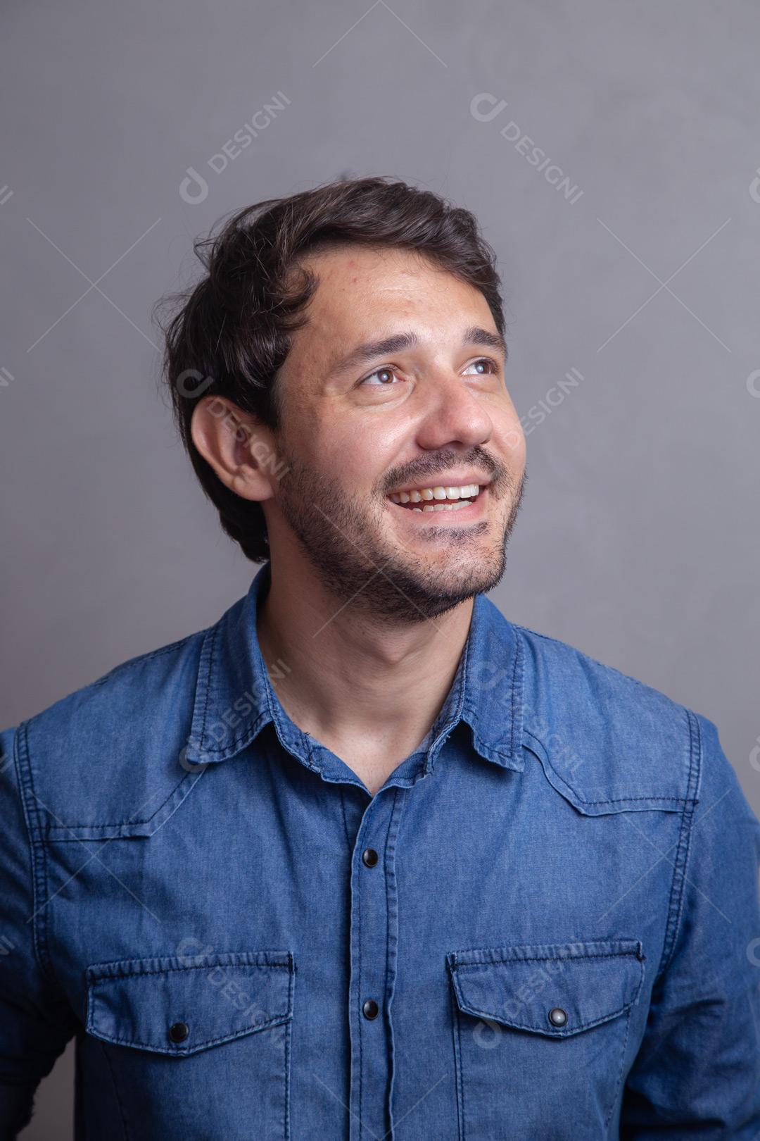 Homem  com roupa social camisa jeans e expressão de felicidade
