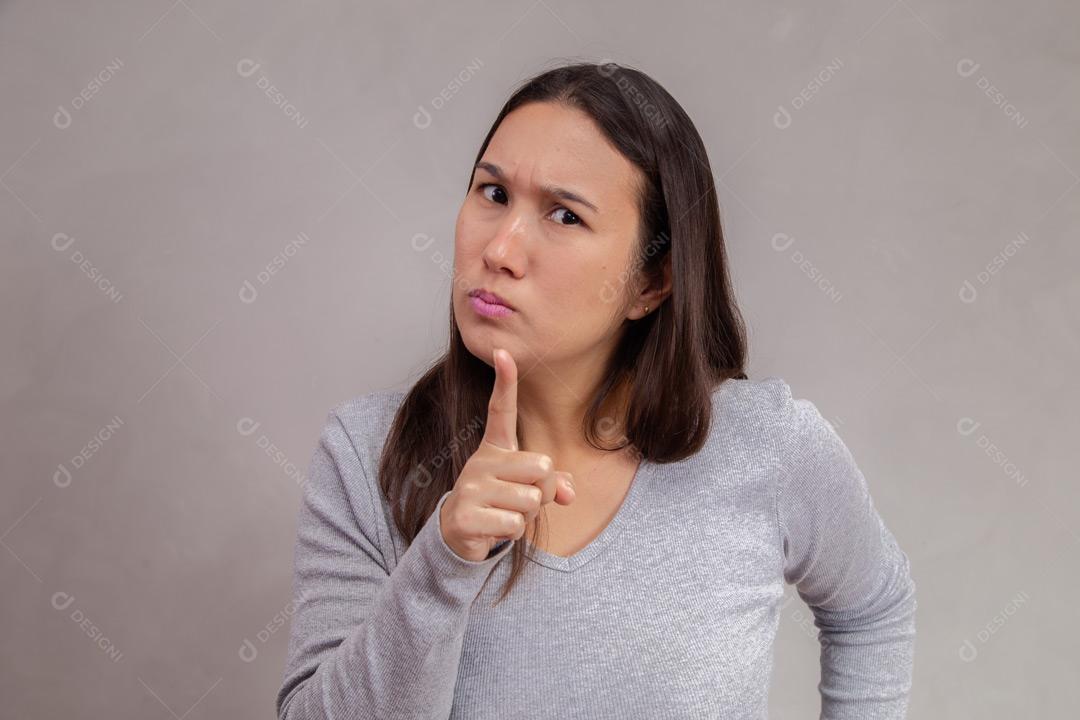 Mulher  com expressão de raiva em fundo cinza