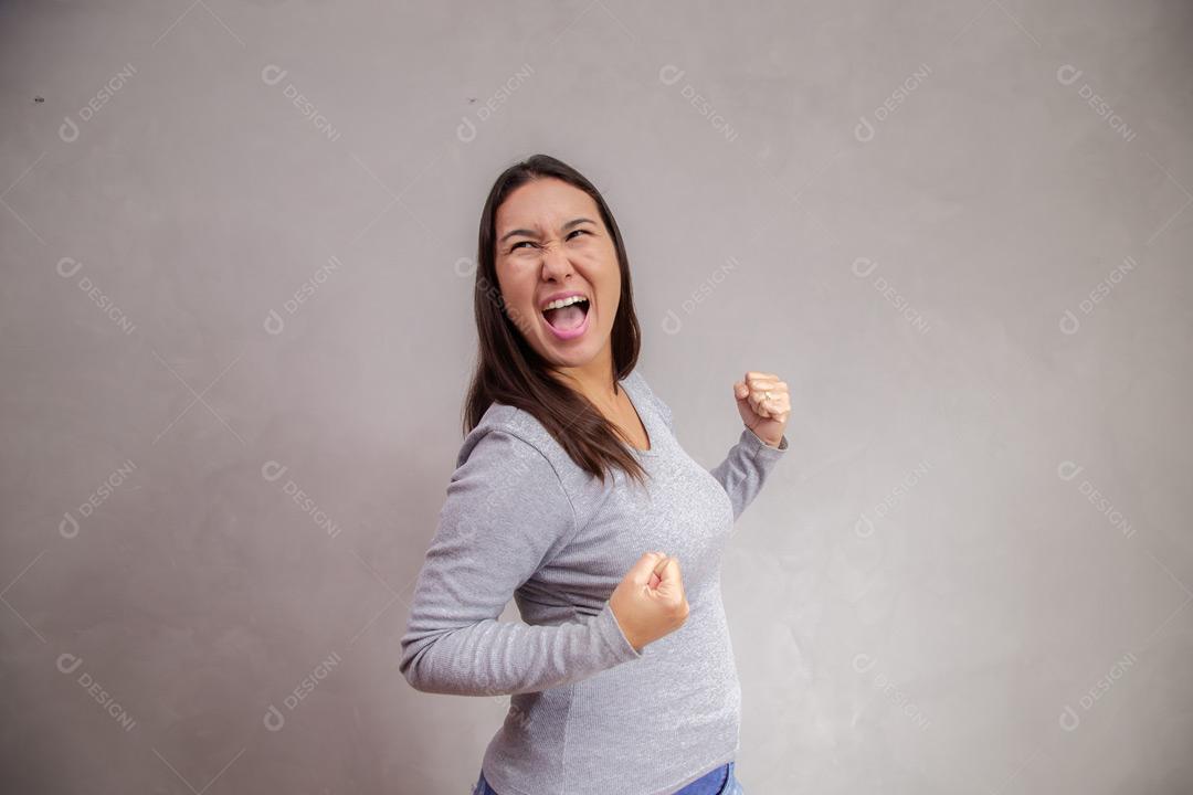 Mulher  com expressão de felicidade em fundo cinza