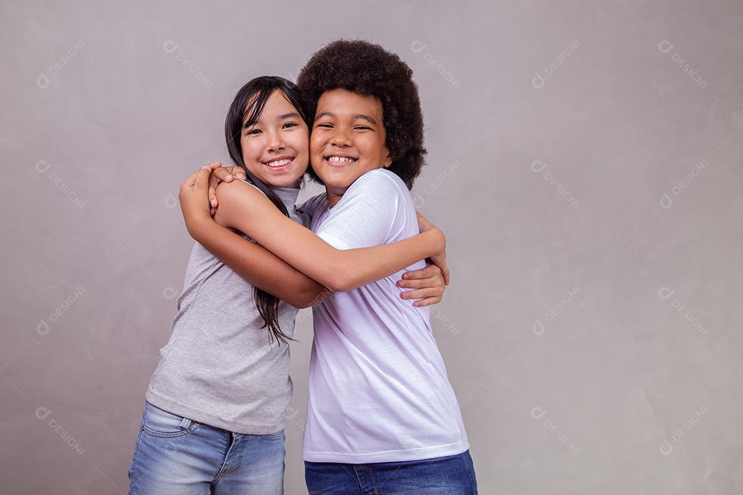 Crianças Japonesa e Afro se abraçando