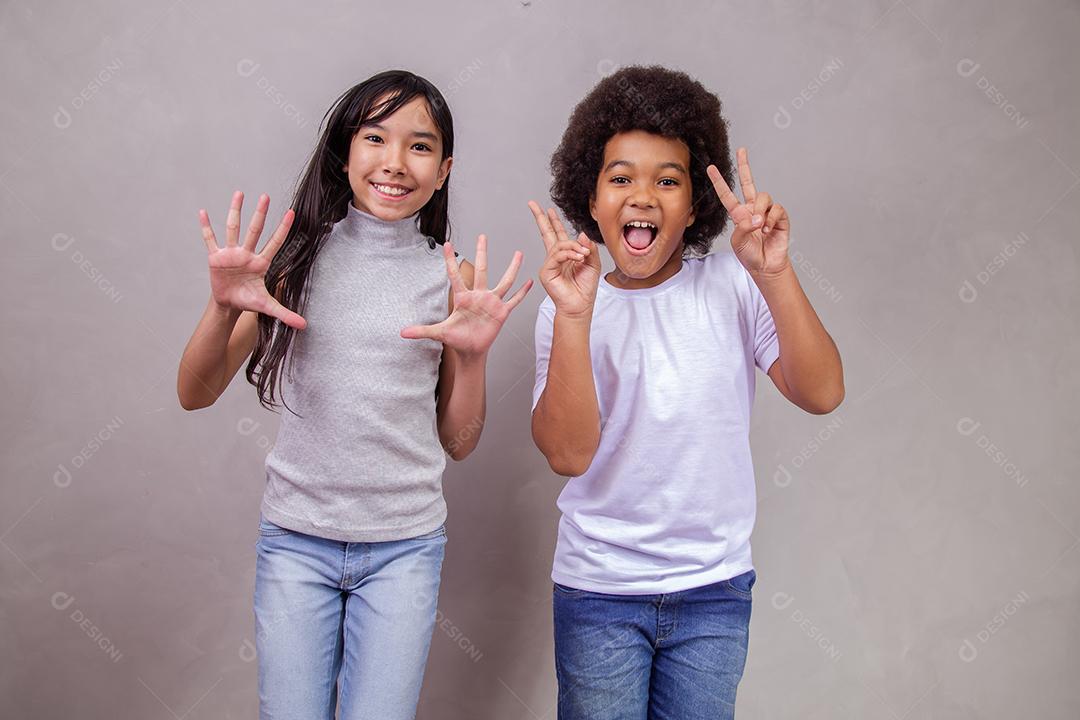 Casal de Crianças Japonesa e Afro fazendo poses para Câmera