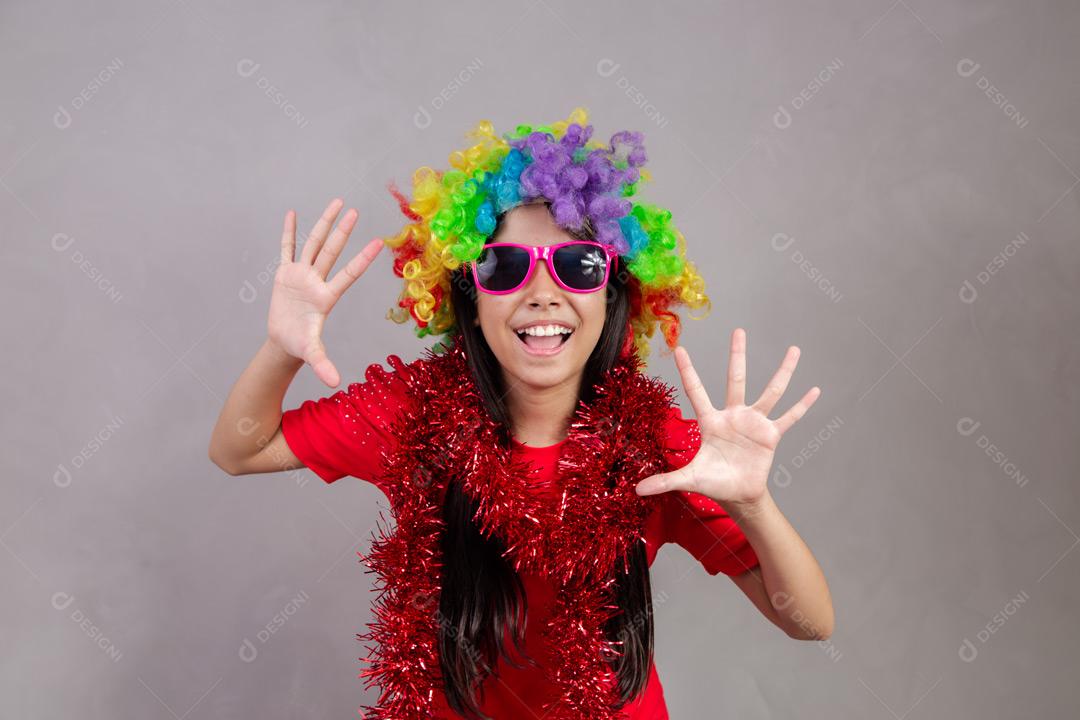 Criança japonesa com peruca colorida e óculos escuro e roupa vermelha em fundo cinza