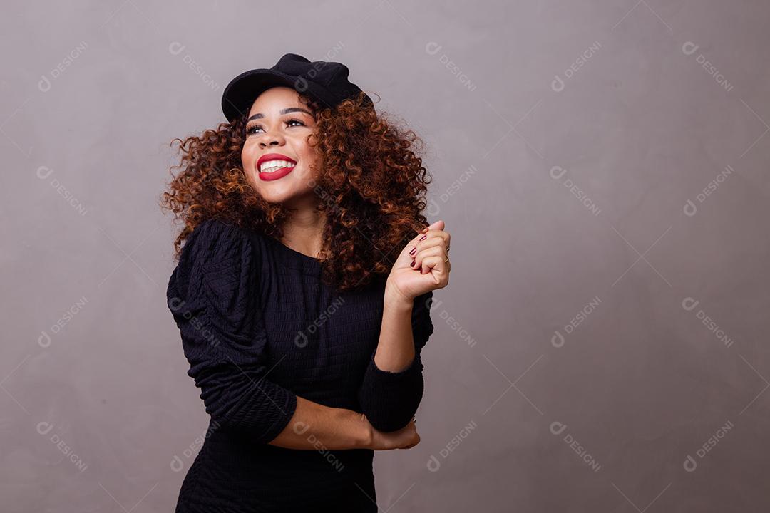 Mulher afro com Cabelos Cacheados Vestindo roupas quentes e usando boina