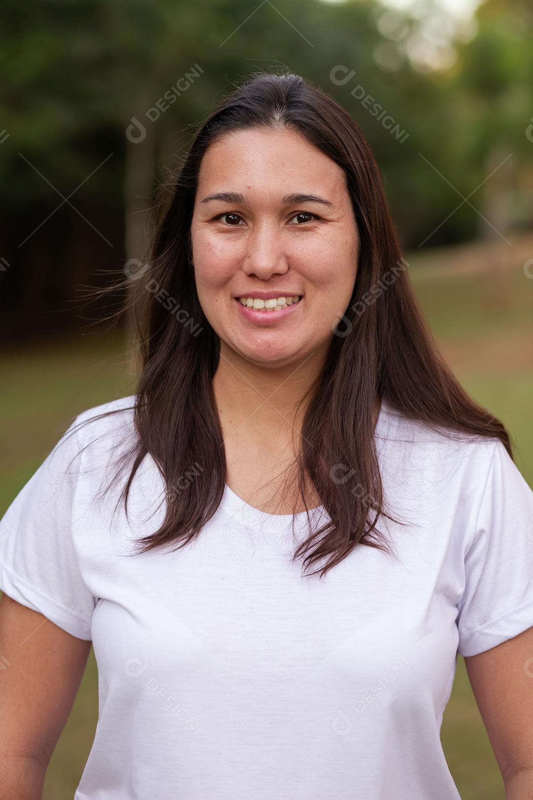Mulher asiática sorridente feliz olhando para a câmera sobre fundo verde. Mulher japonesa no parque sorrindo
