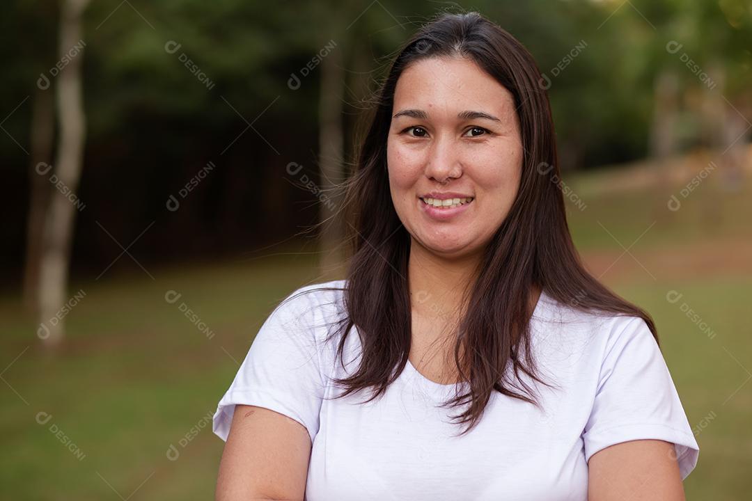 Mulher asiática sorridente feliz olhando para a câmera sobre fundo verde. Mulher japonesa no parque sorrindo