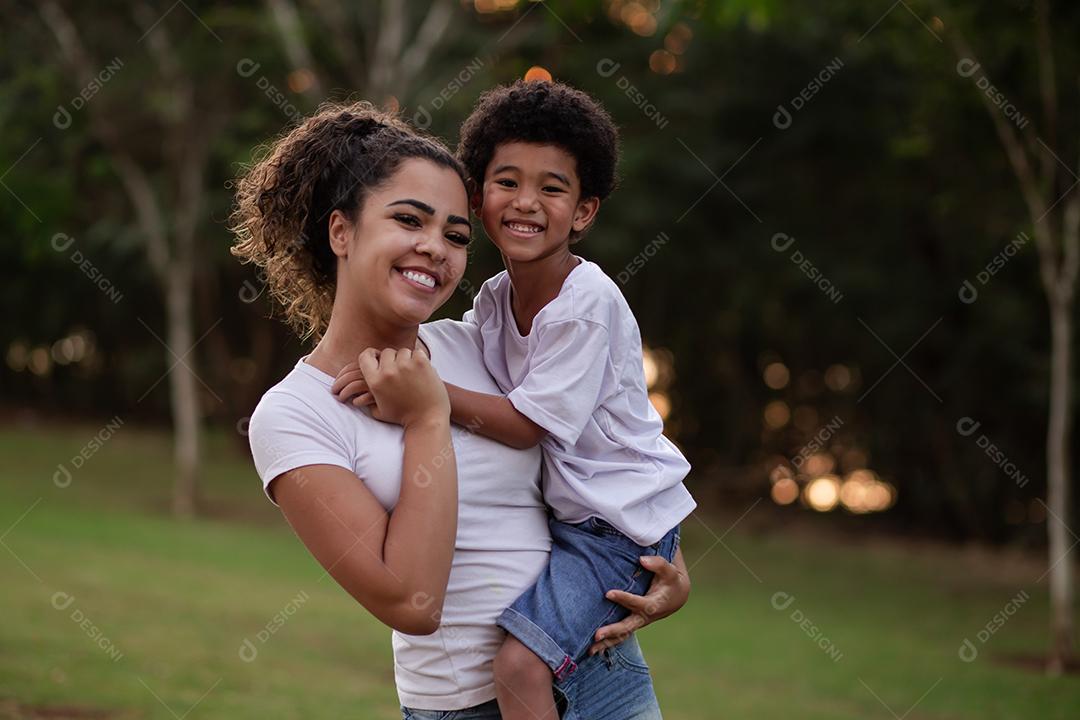 Mãe e Filho Afro no parque sorrindo para a câmera