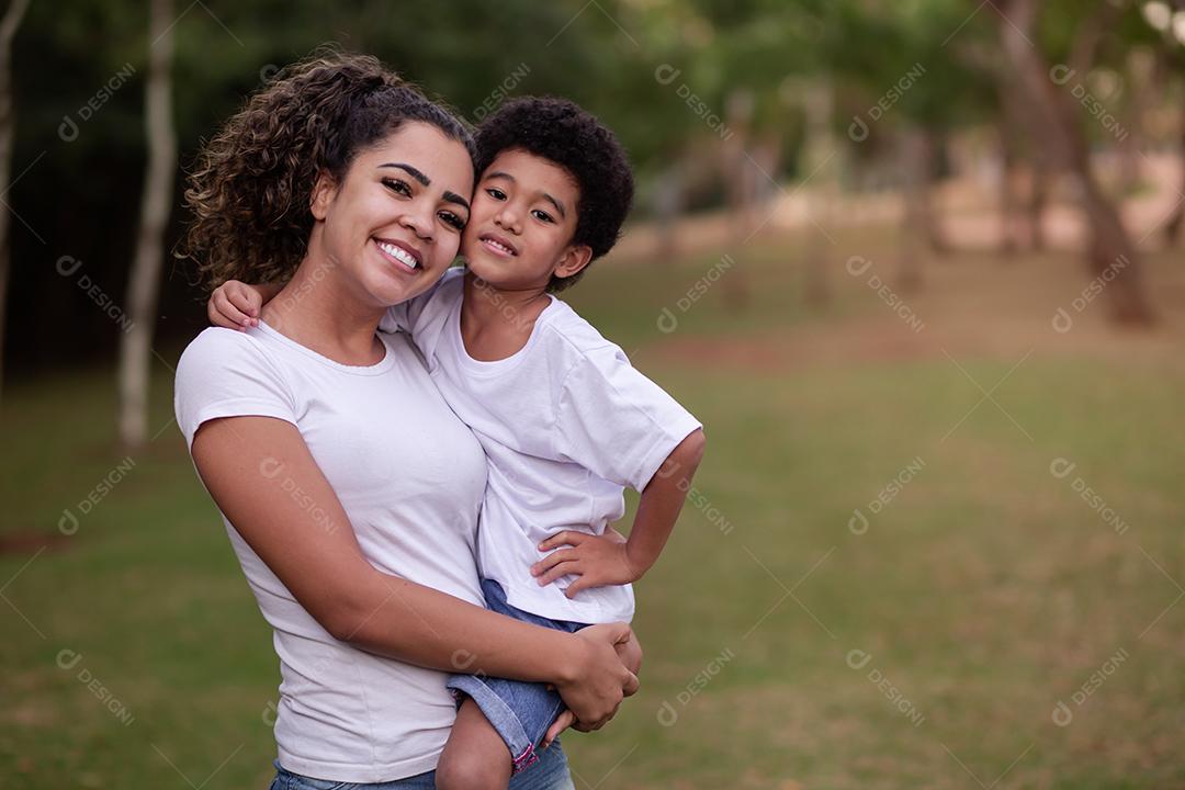 Mãe e Filho Afro no parque sorrindo para a câmera